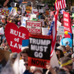 Voluntários colocam mantimentos em carrinhos para famílias que chegam para retirar pedidos on-line no The Pantry by Feeding Hawaii Together, segunda-feira, 10 de novembro de 2025, em Honolulu. (Foto AP/Mengshin Lin)