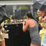 Jovens corredores são vistos na chuva durante o Dia dos Campeões no Hipódromo de Flemington.