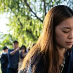 Um enlutado segurando uma flor perto do local para lamentar as vítimas dos incêndios mortais em apartamentos em Hong Kong.