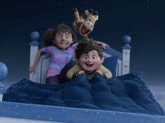 Crítica de In Your Dreams: Crianças lutam para salvar o casamento dos pais em uma aventura animada e pensativa Duas crianças estão deitadas na cama com uma girafa de pelúcia entre elas.