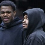 Day'Ron Sharpe (à esquerda) e Cam Thomas, que não jogou devido a lesões, observam a derrota do Nets por 119-109 para o Raptors em 11 de novembro de 2025.
