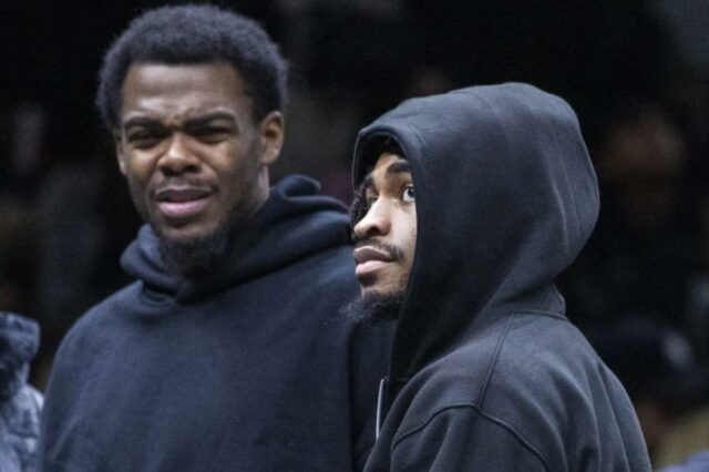 Day'Ron Sharpe (à esquerda) e Cam Thomas, que não jogou devido a lesões, observam a derrota do Nets por 119-109 para o Raptors em 11 de novembro de 2025.