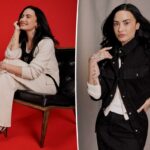 Uma mulher com um suéter vermelho com gola pólo e três botões pretos, combinado com jeans, com uma das mãos no bolso.