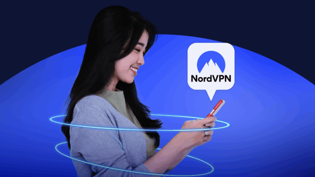 Uma mão segurando um controle remoto de TV aponta para uma smart TV exibindo aplicativos de streaming, sobrepostos por um grande ícone de escudo e a palavra ‘VPN’.