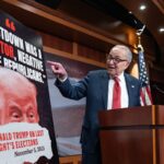 O congressista democrata Don Beyer (à esquerda) carrega uma caixa de comida em um carro de um banco de alimentos na Virgínia no mês passado.