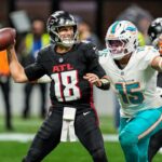 O erback Kirk Cousins ​​(18) passa sob pressão do linebacker do Miami Dolphins Jaelan Phillips (15) durante o primeiro quarto no Mercedes-Benz Stadium.