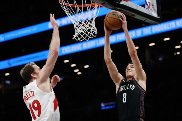 Egor Dëmin tenta enterrar enquanto Jakob Poeltl defende durante a derrota do Nets para o Raptors em 11 de novembro de 2025.