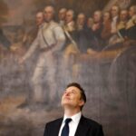 a photo of Elon Musk looking up at the ceiling while standing in front of a historical painting
