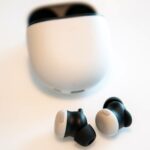 Três pares de Pixel Buds Pro nas cores azul, branco e vermelho dispostos em seus estojos de carregamento.