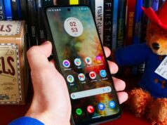 Este é o telefone de US $ 123 que durará dias com uma única carga O Moto G Power (2024) deitado sobre tecido cinza e ao lado de uma estampa de flores