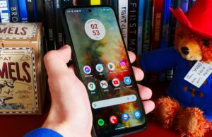 Este é o telefone de US $ 123 que durará dias com uma única carga O Moto G Power (2024) deitado sobre tecido cinza e ao lado de uma estampa de flores