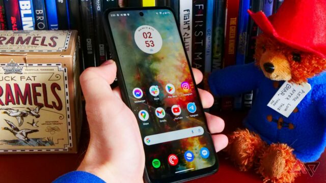 O Moto G Power (2024) deitado sobre tecido cinza e ao lado de uma estampa de flores