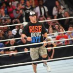 john cena in the ring celebrating with fans at wwe event