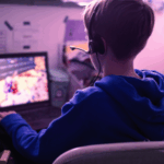 Estudo norueguês identifica ligação entre jogos de computador e aumento do jogo entre adolescentes. Criança jogando no laptop jogando videogame on-line viciante em casa, no quarto dele.