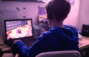Estudo norueguês identifica ligação entre jogos de computador e aumento do jogo entre adolescentes Estudo norueguês identifica ligação entre jogos de computador e aumento do jogo entre adolescentes. Criança jogando no laptop jogando videogame on-line viciante em casa, no quarto dele.
