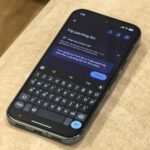 Um Apple iPhone 13 e um Google Pixel 8 próximos um do outro em um teclado, mostrando um documento idêntico do Google Docs na tela