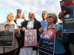 Figura da oposição tunisiana presa e hospitalizada em meio a greve de fome: família Jawhar Ben Mbarek acena durante uma manifestação.
