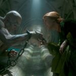 Frankenstein's monster touches hands with a red-haired woman