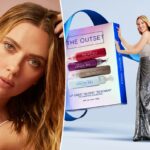 Um tubo de brilho labial The Outset Lip Oasis Glossy Treatment, com o aplicador visível e a tampa colocada na superfície próxima a ele.