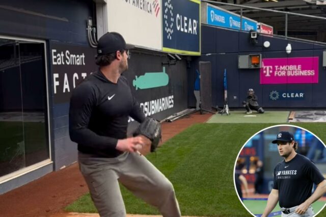 O arremessador do New York Yankees, Gerrit Cole, vestindo uma camiseta e chapéu pretos do Yankees, segurando uma luva preta.