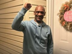 Homem de Illinois finalmente exonerado depois de passar mais de 30 anos na prisão por assassinato que não cometeu Um homem com capuz azul levanta o punho em um gesto de triunfo ou solidariedade.