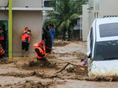 Indonésia corre para evacuar residentes de Sumatra enquanto mortes por enchentes sobem para 34 Um homem carrega seu filho enquanto atravessa as enchentes após fortes chuvas em uma área residencial de Darul Imarah, nos arredores de Banda Aceh, em 27 de novembro de 2025. (Foto de CHAIDEER MAHYUDDIN / AFP)