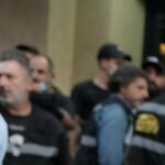 Oficiais de segurança se reúnem perto de veículos destruídos no local onde um ataque israelense atingiu um prédio de apartamentos em Dahiyeh no domingo.