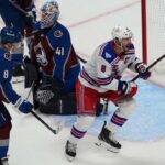 O pivô do New York Rangers, JT Miller, reage após marcar um gol contra o goleiro do Colorado Avalanche, Scott Wedgewood, enquanto o defensor Cale Makar observa.