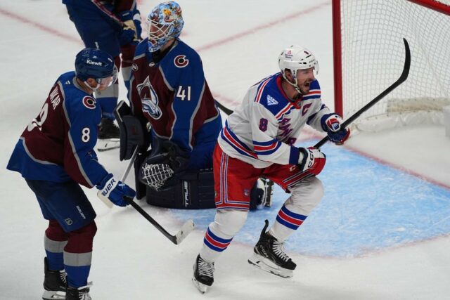 O pivô do New York Rangers, JT Miller, reage após marcar um gol contra o goleiro do Colorado Avalanche, Scott Wedgewood, enquanto o defensor Cale Makar observa.