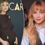 Jennifer Lawrence com camisa azul e colete cinza no desfile da Christian Dior.