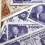 Um close de uma pilha de cupons de alimentação do Departamento de Agricultura dos EUA.