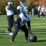 O lado defensivo dos Jets, Jowon Briggs (91), rola uma bola medicinal durante o treino.