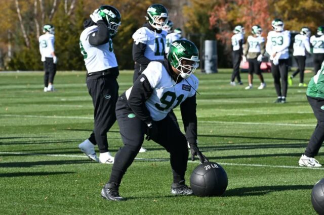 O lado defensivo dos Jets, Jowon Briggs (91), rola uma bola medicinal durante o treino.