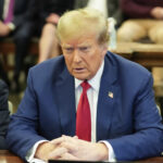 O senador Edward Kennedy, D-Mass., à direita, dá as boas-vindas ao juiz do Tribunal Distrital dos EUA, Mark Wolf, de volta ao palco depois de cair acidentalmente da borda durante uma cerimônia de naturalização na Biblioteca John F. Kennedy em Boston, segunda-feira, 21 de julho de 2003. Cerca de 100 pessoas foram naturalizadas durante a cerimônia. O juiz Wolf não ficou gravemente ferido na queda. (Foto AP/Charles Krupa)