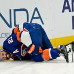 O pivô do New York Islanders, Kyle Palmieri (21), cai no gelo após uma lesão.