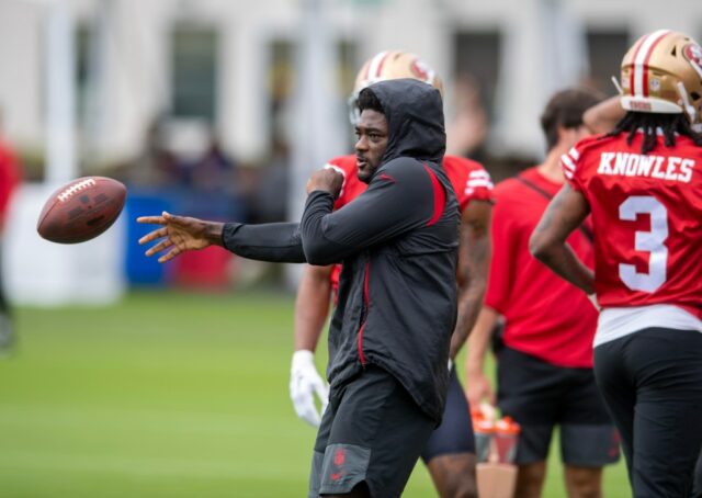 Brandon Aiyuk, do San Francisco 49ers, observa companheiros de equipe durante o treino no campo de treinamento do 49ers nas instalações de treino do Levi's Stadium em Santa Clara, Califórnia, na quinta-feira, 24 de julho de 2025. (Doug Duran/Bay Area News Group)