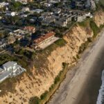 As ondas quebram perto de casas de praia em Malibu em 28 de dezembro de 2023. Foto de Damian Dovarganes, AP Photo