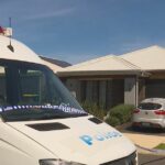 Um carro da polícia na frente de uma casa em Melonba após a prisão de uma mulher.