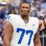 Alaric Jackson nº 77 do Los Angeles Rams observa durante o hino nacional antes de um jogo de futebol americano da NFL contra o Baltimore Ravens no M&T Bank Stadium em 12 de outubro de 2025 em Baltimore, Maryland.