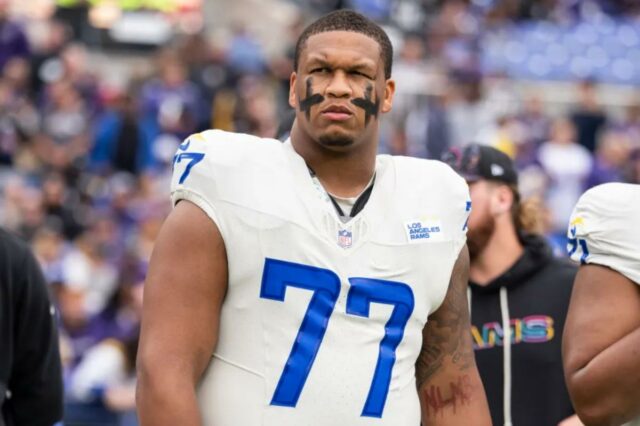 Alaric Jackson nº 77 do Los Angeles Rams observa durante o hino nacional antes de um jogo de futebol americano da NFL contra o Baltimore Ravens no M&T Bank Stadium em 12 de outubro de 2025 em Baltimore, Maryland. 