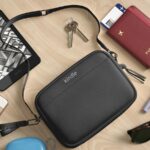 A bolsa tipo estilingue do Kindle sendo usada ao ar livre, com os dois estilos à vista.