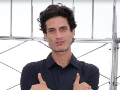 Neto de JFK, Jack Schlossberg, anuncia candidatura ao Congresso Jack Schlossberg está diante de várias barras de metal. Seus braços estão cruzados sobre o peito e ele está esticando o polegar e o dedo mínimo.