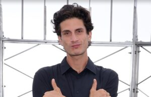 Neto de JFK, Jack Schlossberg, anuncia candidatura ao Congresso Jack Schlossberg está diante de várias barras de metal. Seus braços estão cruzados sobre o peito e ele está esticando o polegar e o dedo mínimo.