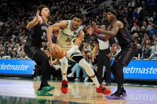O atacante do Milwaukee Bucks, Giannis Antetokounmpo (34), faz uma bandeja contra o atacante do Brooklyn Nets, Jalen Wilson (22).