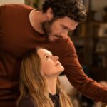 A man leans over a woman smiling