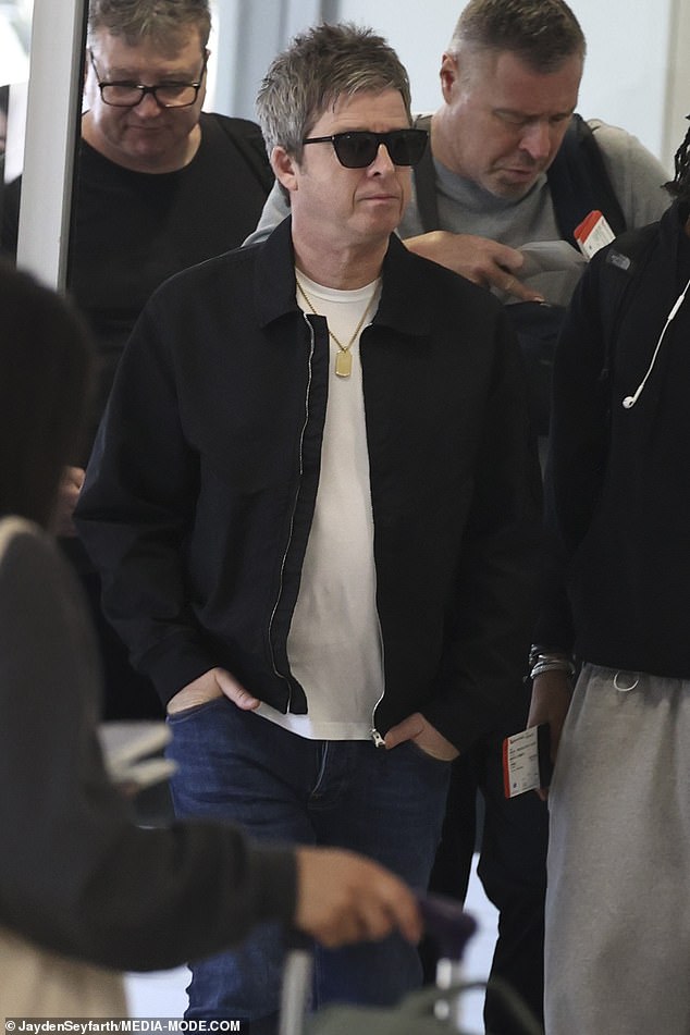Noel Gallagher parece elegante sem esforço ao sair da Austrália A estrela do Oasis, Noel Gallagher, parecia elegante na quinta-feira, quando foi visto no aeroporto de Sydney se preparando para deixar a Austrália, após a turnê de reunião de sua banda, com ingressos esgotados.