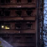 Um bombeiro vasculha um prédio.