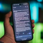 O alto-falante Nest Audio com as luzes ativas, sobre uma pequena pilha de livros