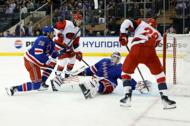 O defensor do Carolina Hurricanes, Sean Walker, marcou um gol contra o goleiro do New York Rangers, Igor Shesterkin.