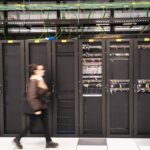 A visitor walks past a computer bay at the PA10 data center, operated by Equinix Inc., in Paris, France.